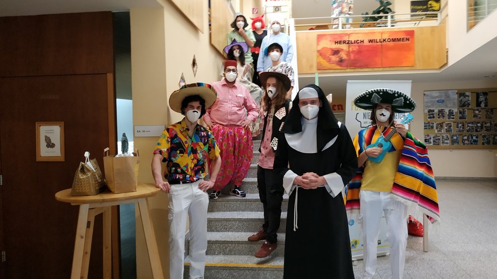 Verkleidete MitarbeiterInnen stehen am Stiegenaufgang.