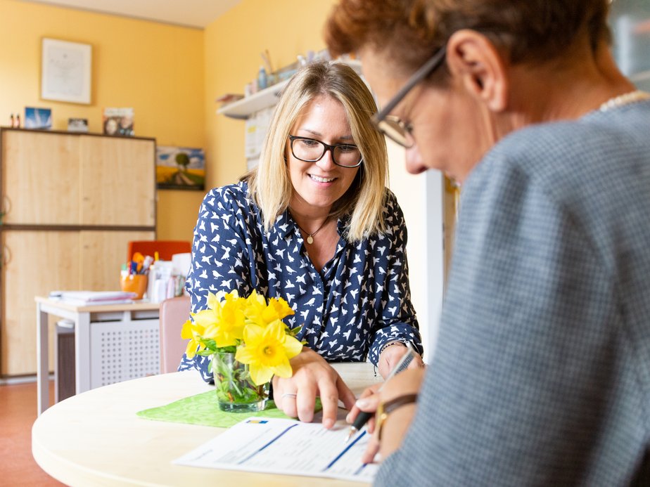 Zwei Betreuerinnen sitzen bei einem Tisch.