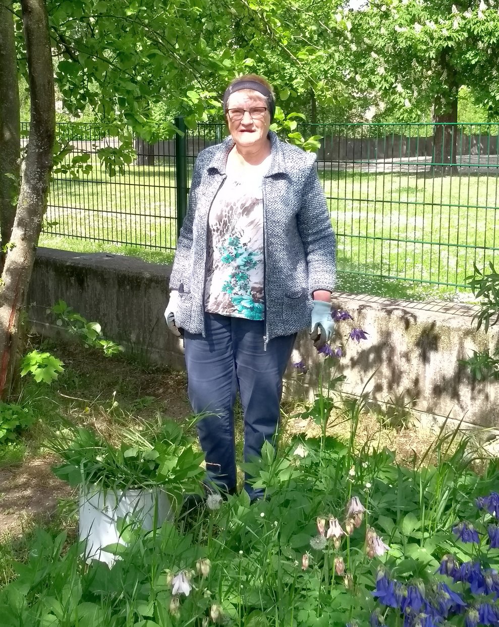 Eine Frau reißt Unkraut aus.