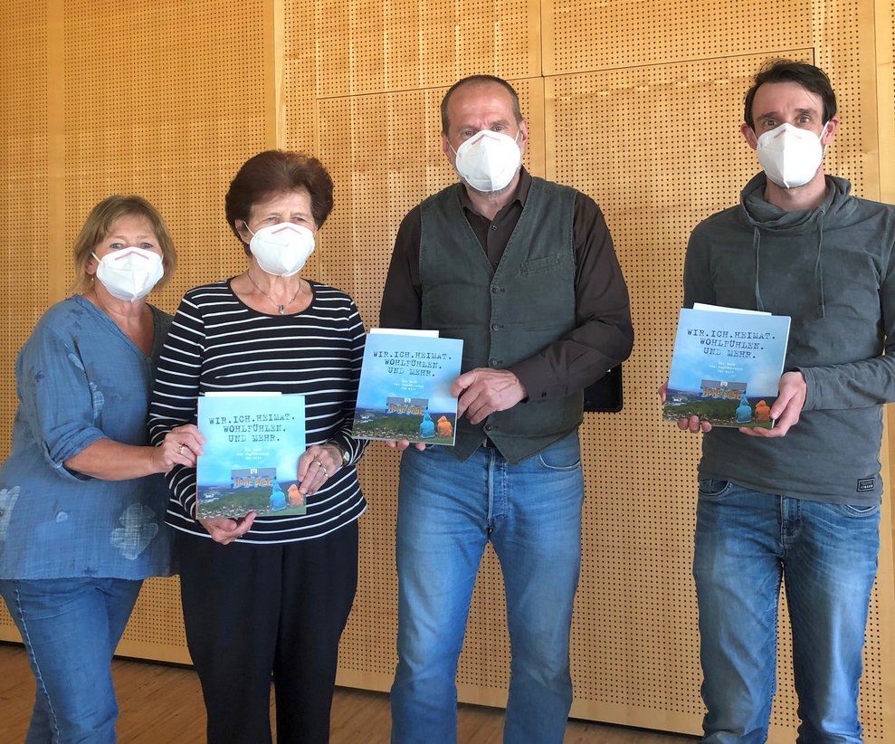 Vier Personen, die jeweils ein Buch in der Hand halten.