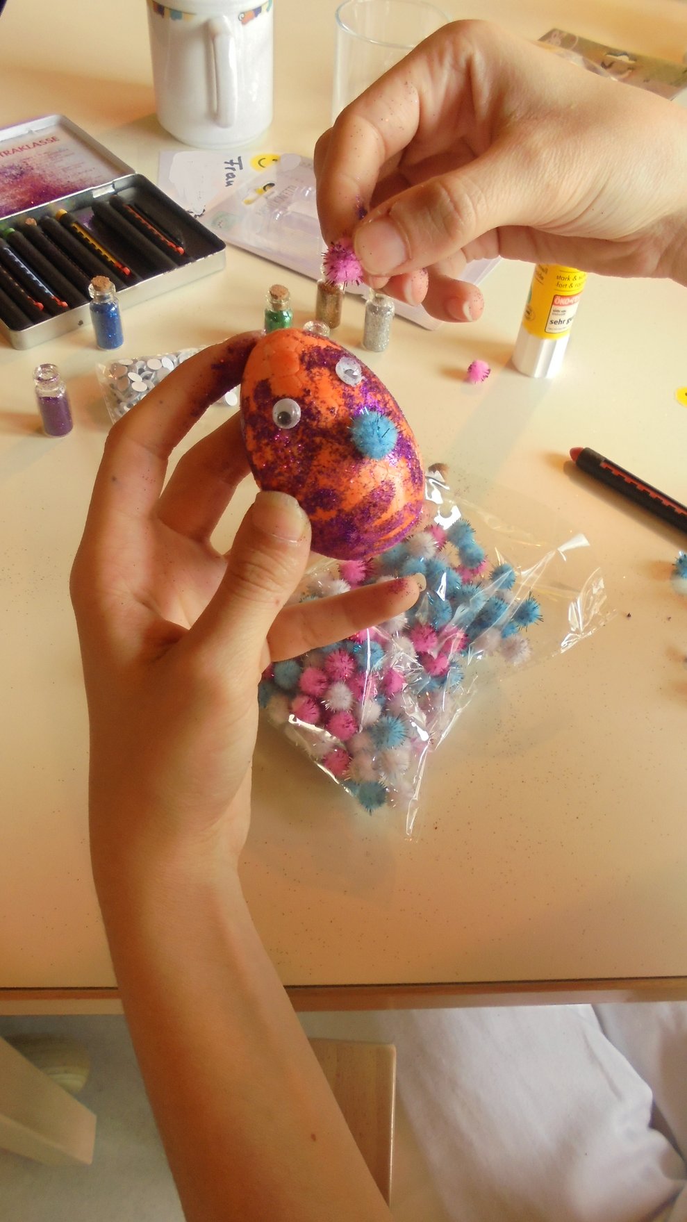 Eine Person dekoriert ein Osterei.