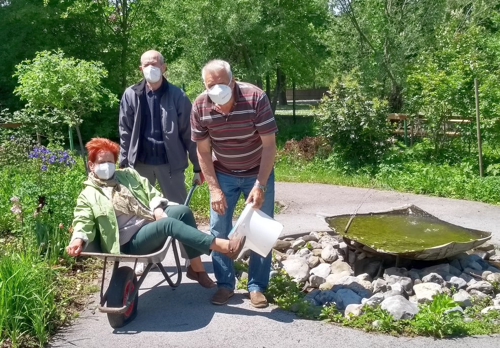 Eine Frau sitzt in einer Scheibtruhe.