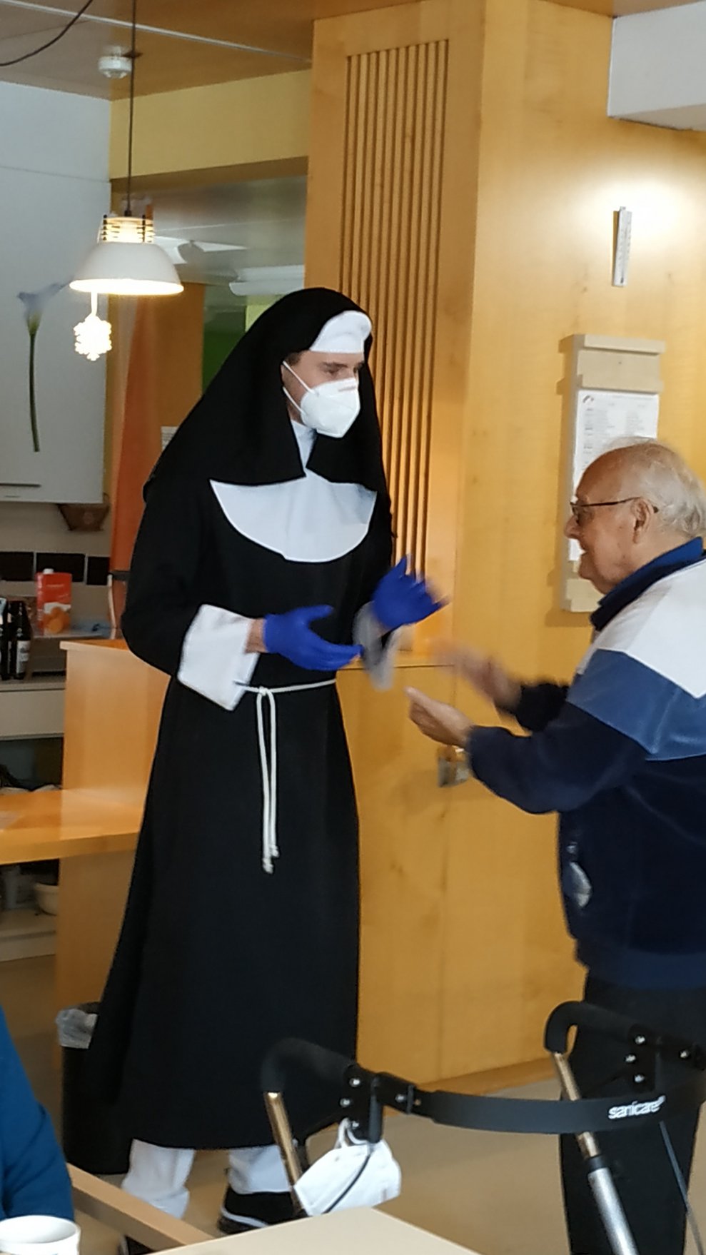 Ein Betreuer, der als Nonne verkleidet ist, tanzt mit einem Bewohner.