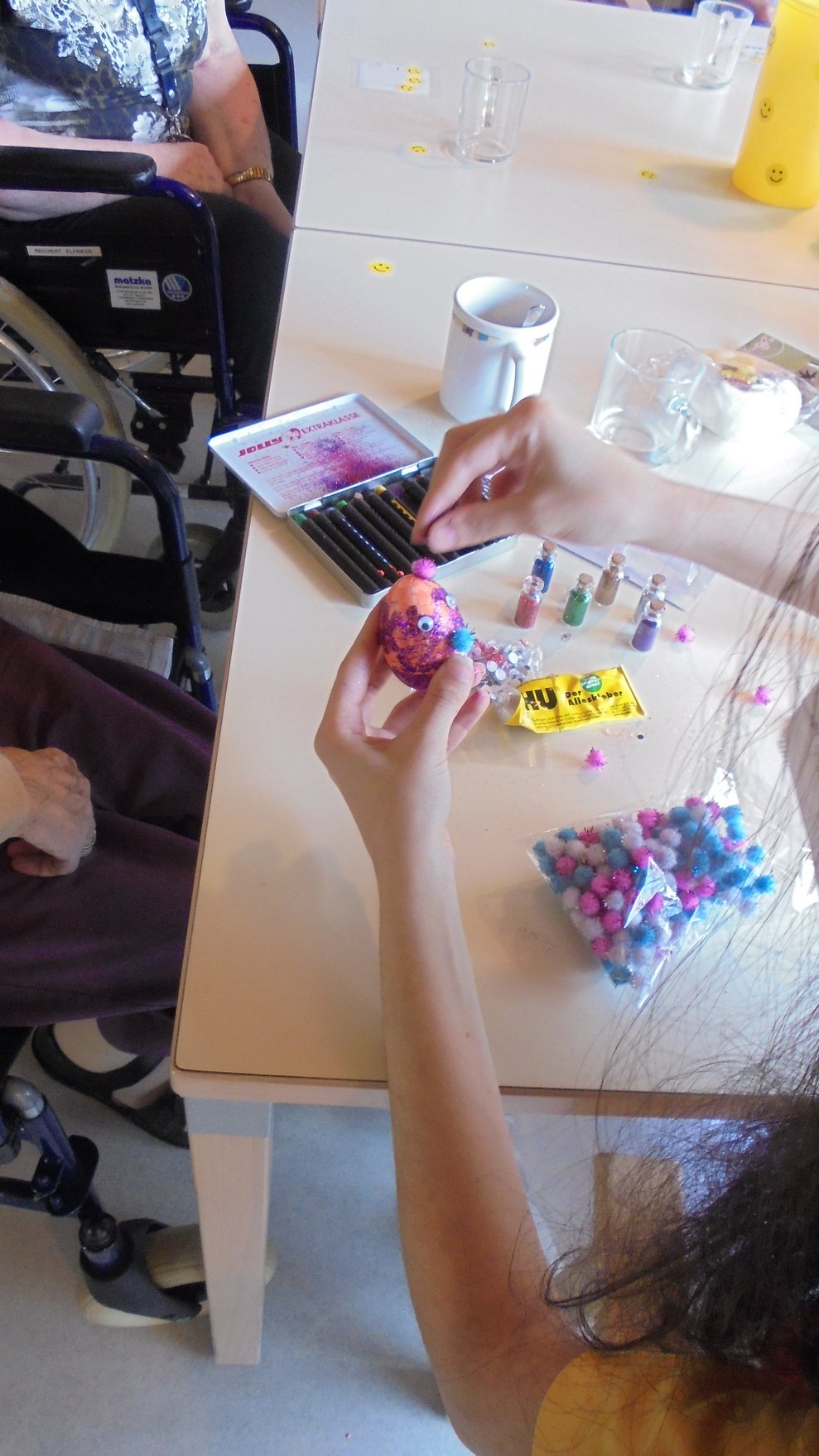 Die Betreuerin dekoriert Ostereier.